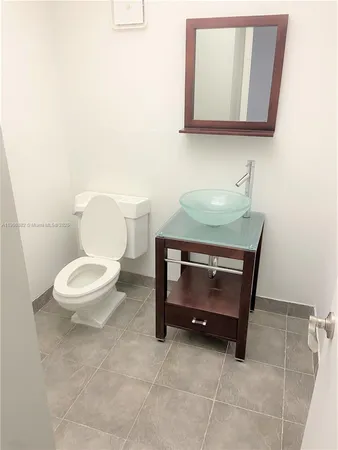 a bathroom with a toilet a sink and mirror