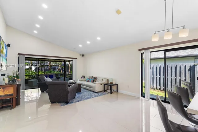 a living room with furniture a flat screen tv and a window