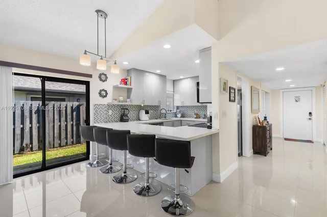 a kitchen with stainless steel appliances kitchen island granite countertop a sink and a refrigerator