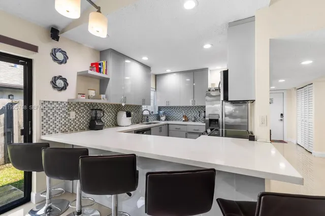 a kitchen with kitchen island a stove a table and chairs in it