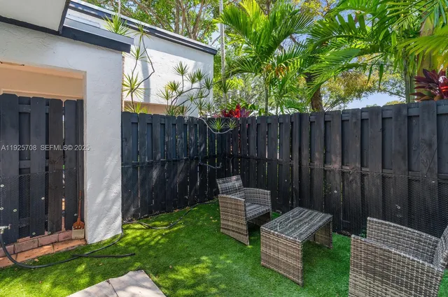 a view of a wooden bench in back yard of a house