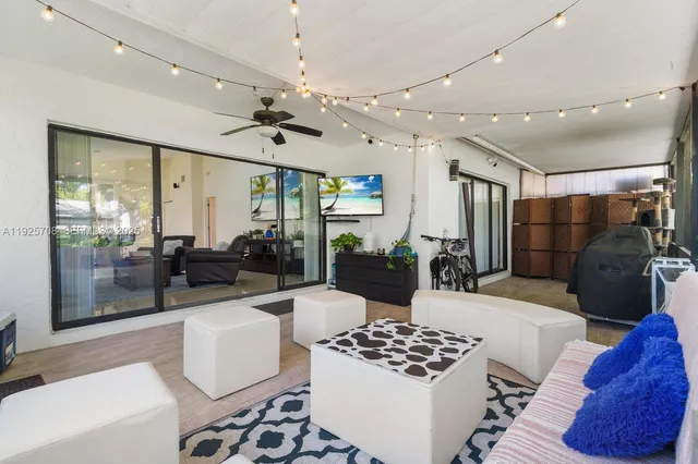a living room with furniture a rug and kitchen view