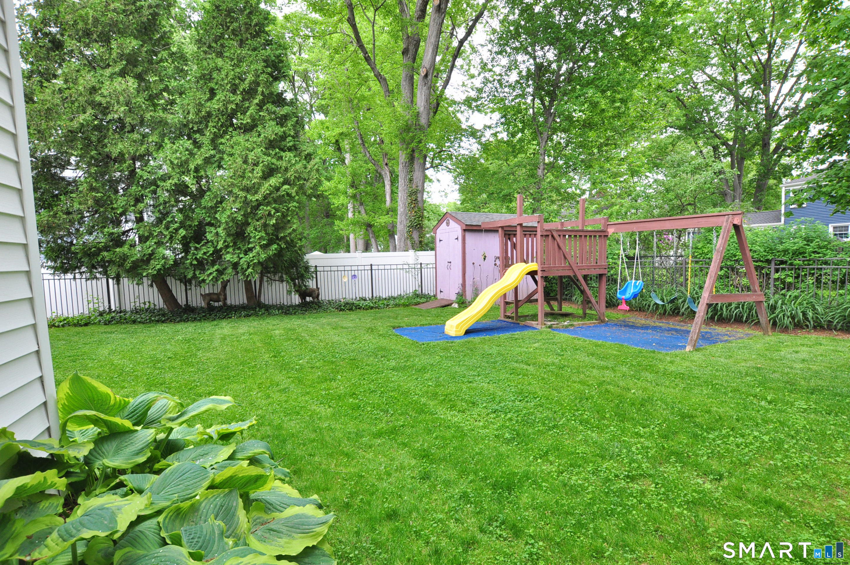 44 Miamis Road West Hartford, CT 06117 - Photo 34 of 39 a view of a backyard with a slide trees and wooden fence
