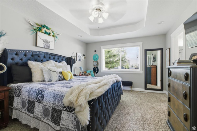 772 East 600 South Preston, ID 83263 - Photo 17 of 35 Recessed tray ceiling with a ceiling fan, light gray wall paint, and plush carpet flooring