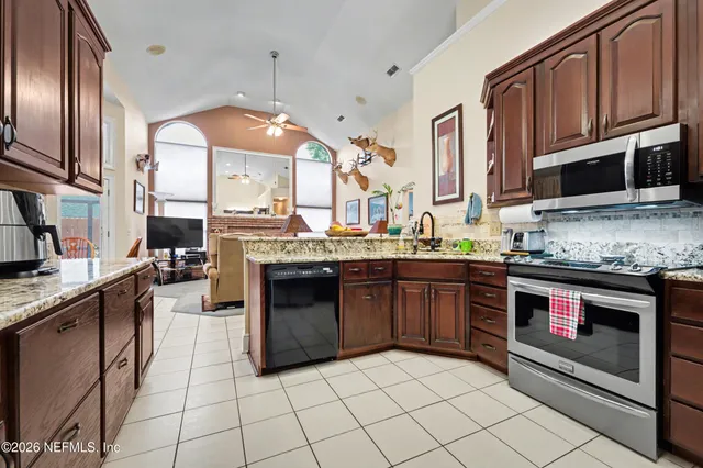 a kitchen with stainless steel appliances granite countertop a stove a sink and a microwave