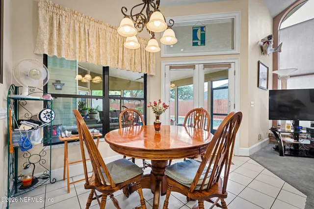 a dining room with furniture a chandelier and wooden floor