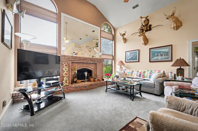 a living room with furniture a flat screen tv and a fireplace