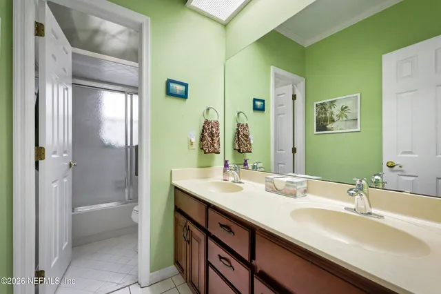 a bathroom with a double vanity sink a mirror and a shower