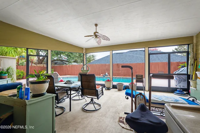 a living room with patio furniture and a floor to ceiling window