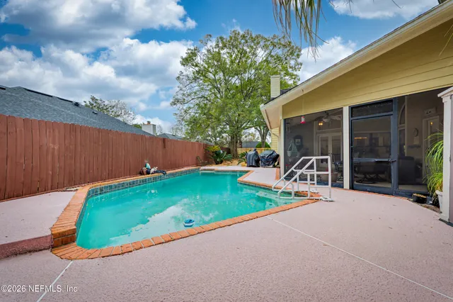 a view of backyard with swimming pool and outdoor seating
