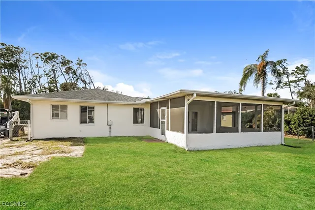 a view of a house with a yard and potted plants