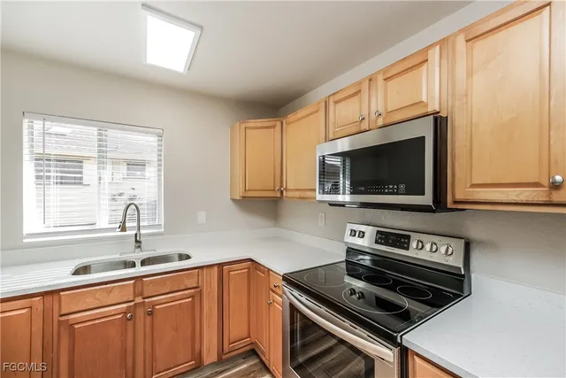 a kitchen with wooden cabinets a sink and a stove top oven