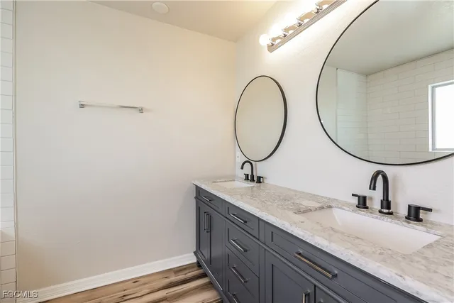 a bathroom with a granite countertop sink and a mirror