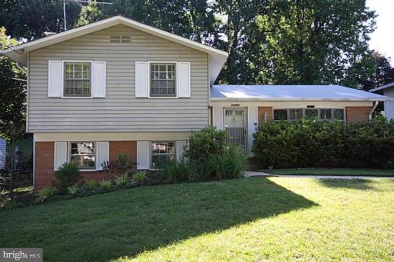 a front view of a house with a yard and trees