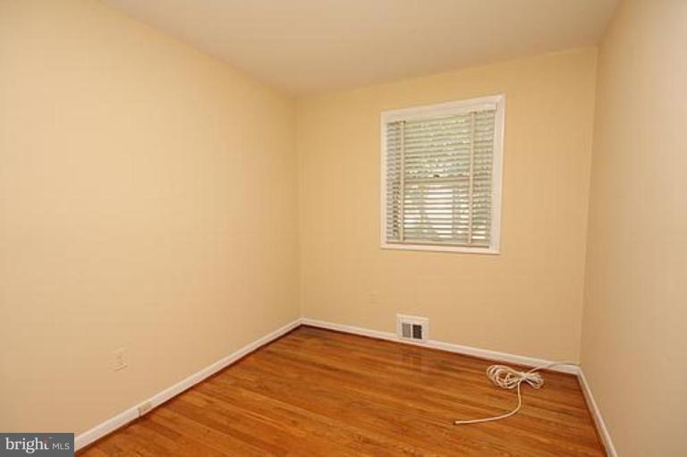 12707 Barbara Road Silver Spring, MD 20906 - Photo 17 of 21 a view of an empty room with wooden floor and a window