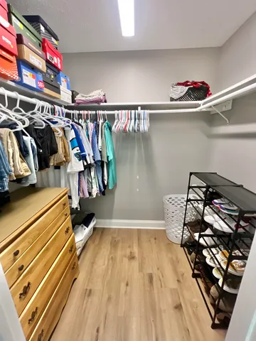 a view of walk in closet with clothes and shoes