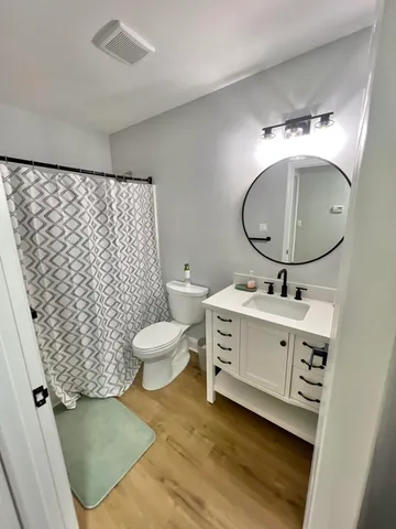 a bathroom with a sink mirror vanity and toilet