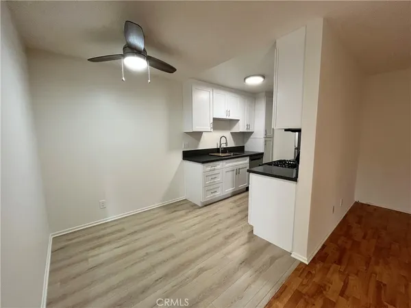 a kitchen with granite countertop white cabinets and white appliances