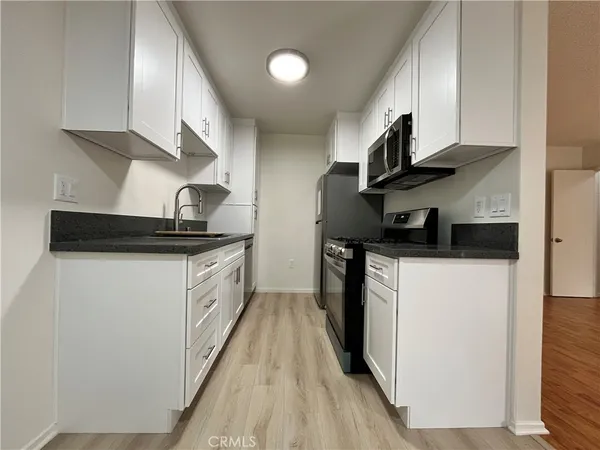 a kitchen with stainless steel appliances granite countertop a sink a stove and a refrigerator