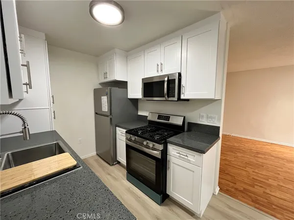 a kitchen with granite countertop a stove and a sink
