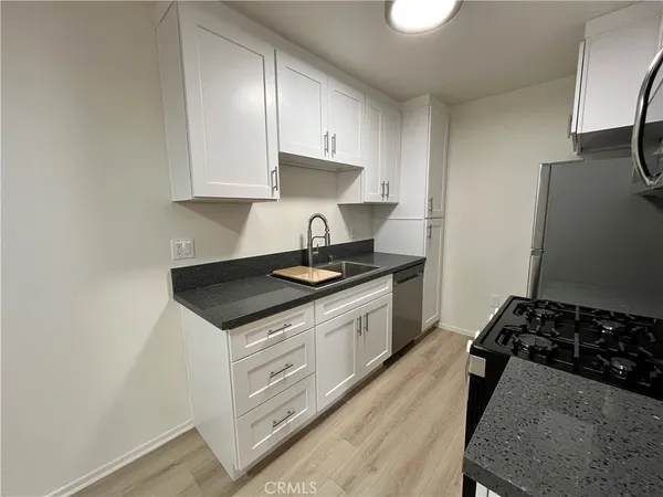a kitchen with stainless steel appliances granite countertop a stove a sink and a refrigerator