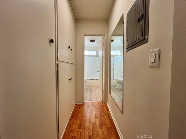 a view of a hallway with wooden floor and glass door