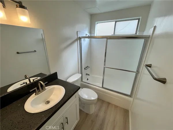 a bathroom with a granite countertop sink toilet and shower