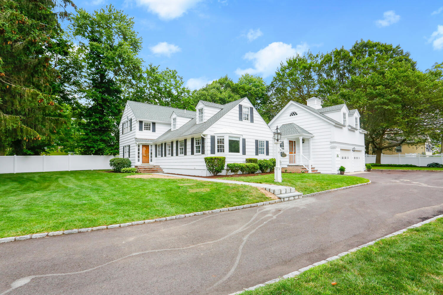 110 Gower Road New Canaan, CT 06840 - Photo 1 of 39 a view of a white house with a big yard and large trees