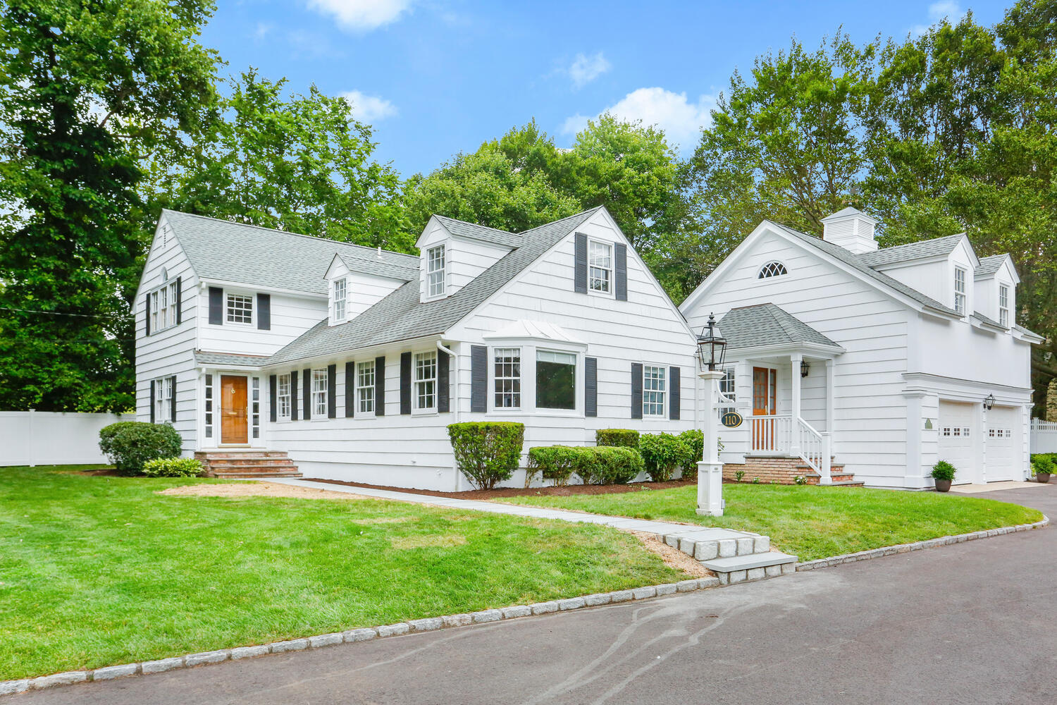 110 Gower Road New Canaan, CT 06840 - Photo 2 of 39 a front view of a house with a garden and plants