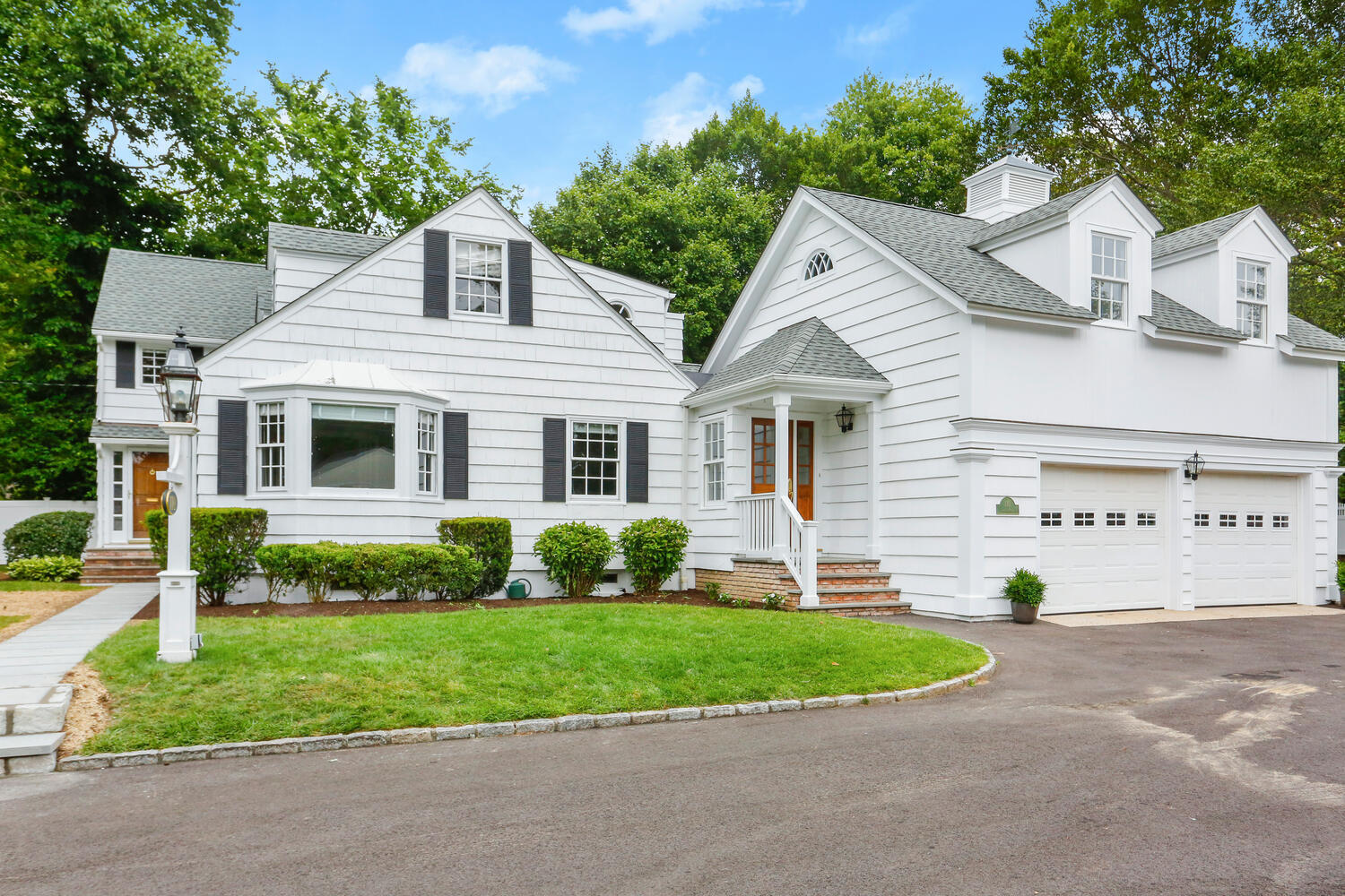 110 Gower Road New Canaan, CT 06840 - Photo 34 of 39 a view of a white house next to a yard and large trees