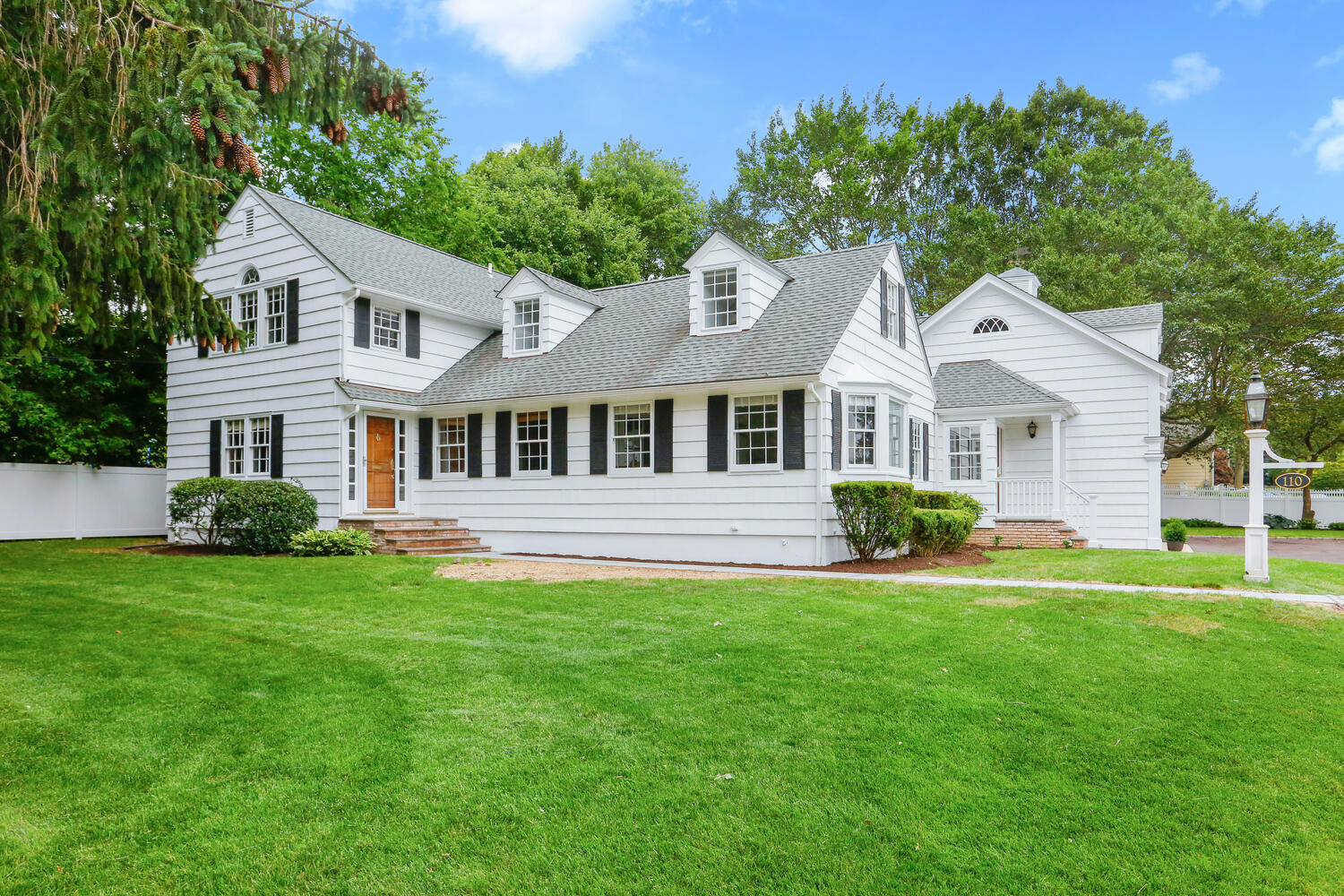 110 Gower Road New Canaan, CT 06840 - Photo 35 of 39 a front view of a house with a garden