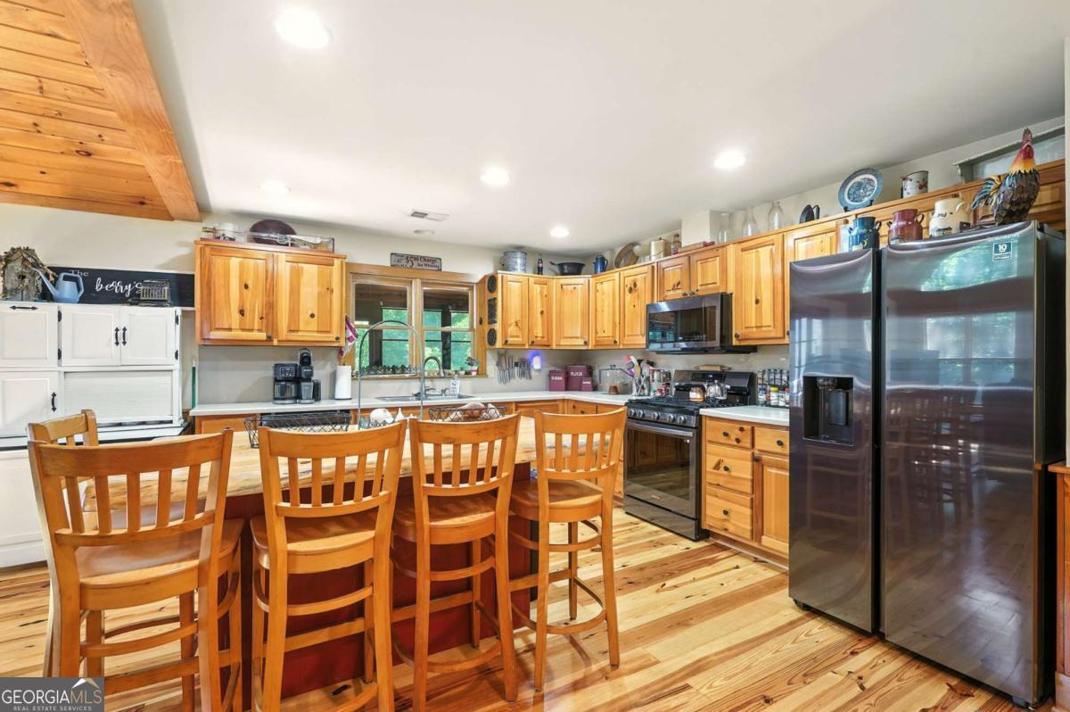 772 Rickman Airfield Road Clayton, GA 30525 - Photo 26 of 64 a kitchen with stainless steel appliances kitchen island granite countertop a refrigerator and microwave