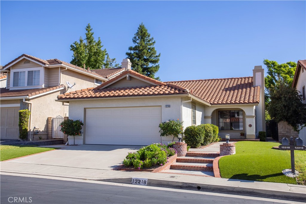a front view of a house with plants and garage