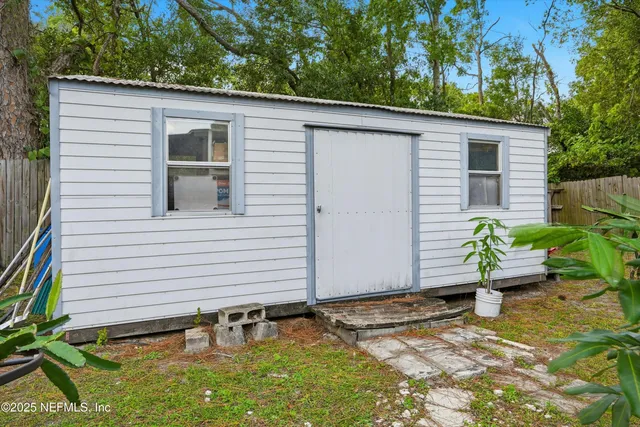 a backyard of a house with plants and chairs