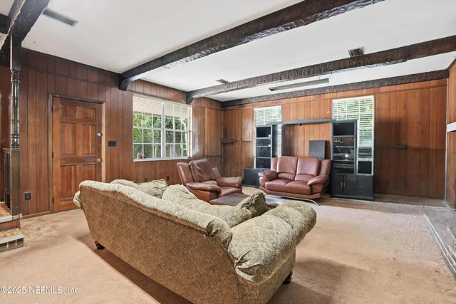 a living room with furniture and large windows