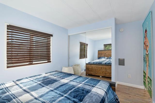 a bedroom with a bed and wooden floor