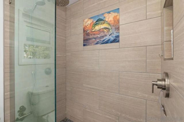 a bathroom with a painting on the wall and shower