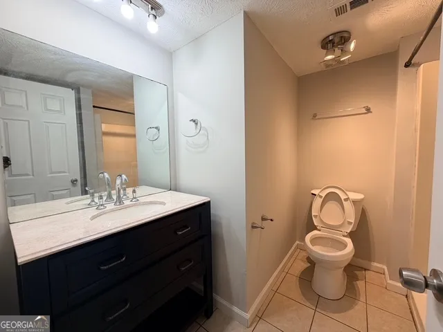 a bathroom with a toilet sink mirror and vanity