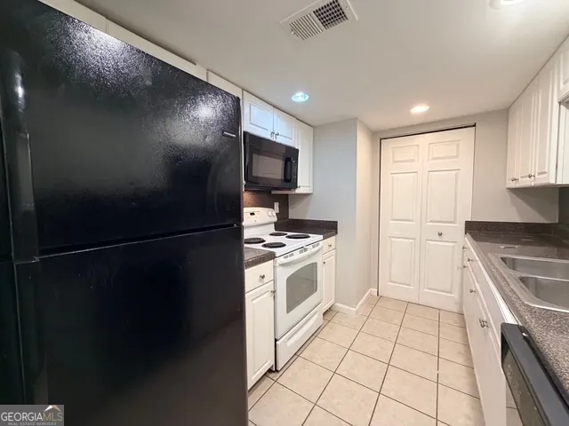 a kitchen with stainless steel appliances granite countertop a refrigerator a stove a sink and a microwave