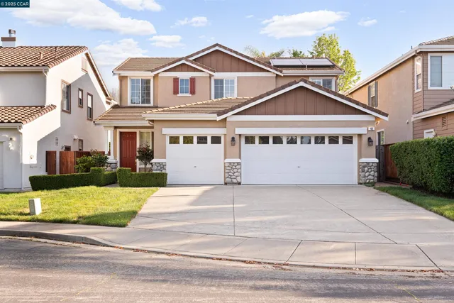a view of a white house with large windows and a yard in front of it