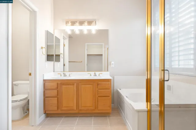 a spacious bathroom with a tub sink and mirror