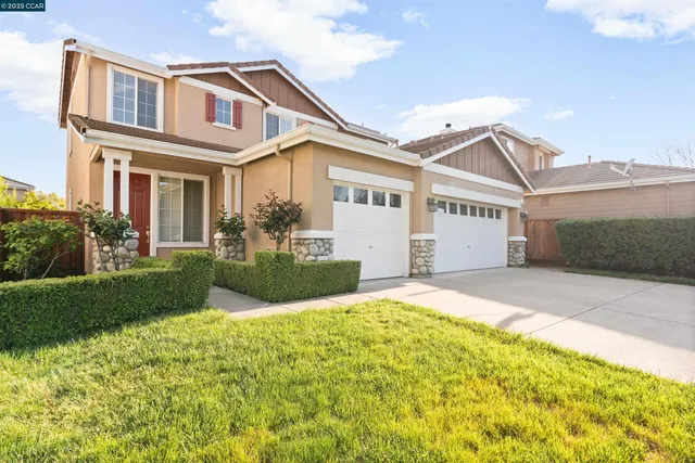 a view of a white house with a big yard and potted plants