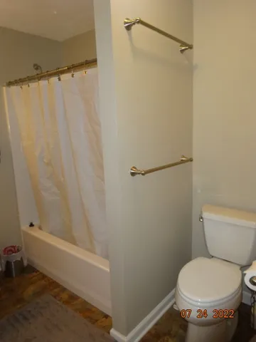 a white toilet sitting next to a shower