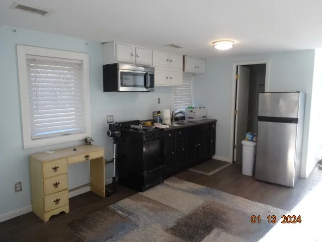 a kitchen with stainless steel appliances kitchen island granite countertop a refrigerator a stove a sink and a microwave