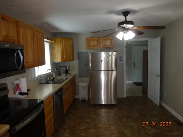 a kitchen with a refrigerator and a stove top oven