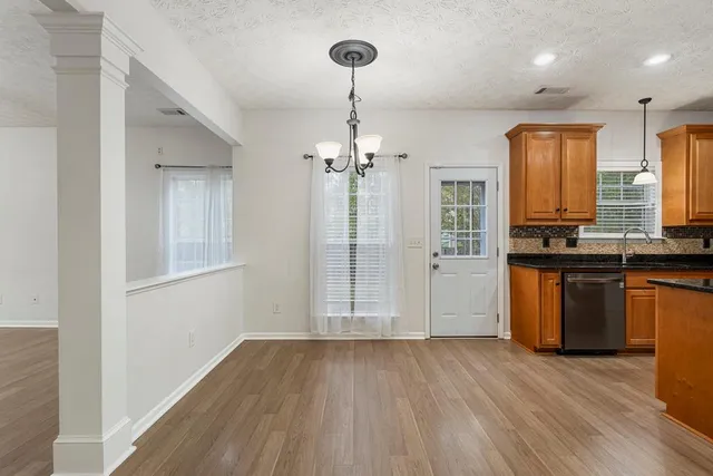 a view of a kitchen with wooden floor and a refrigerator