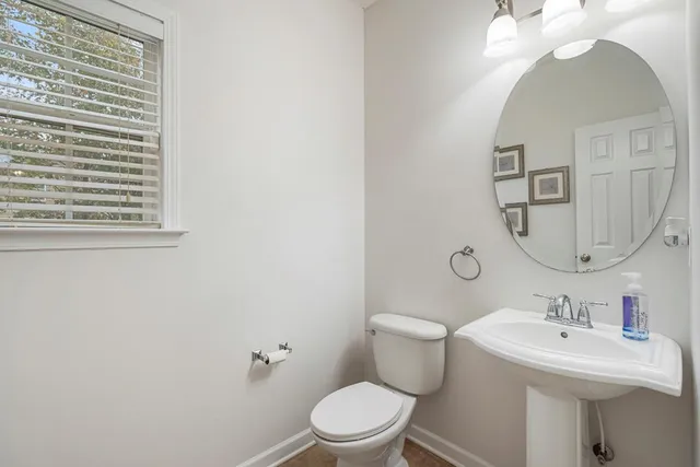 a bathroom with a toilet a sink and mirror