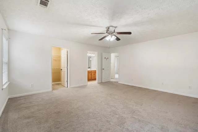 an empty room with a ceiling fan and a window