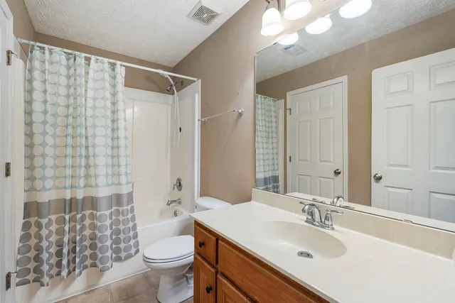 a bathroom with a sink toilet mirror and shower
