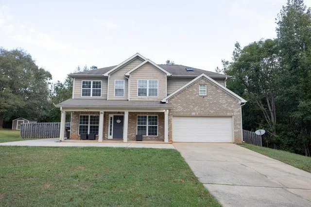a front view of a house with a garden and yard